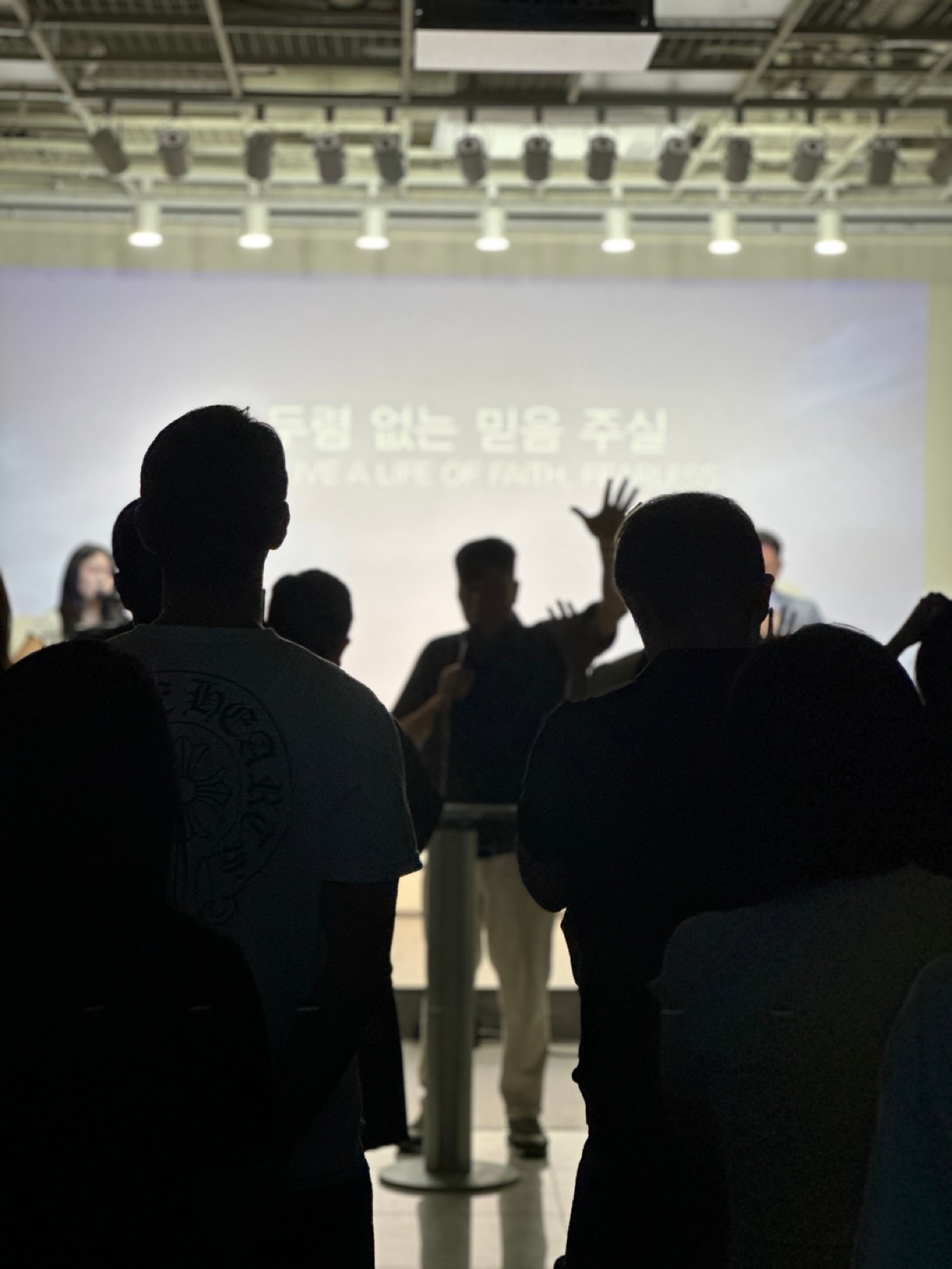 The congregation singing, in silhouette, during the Sunday service